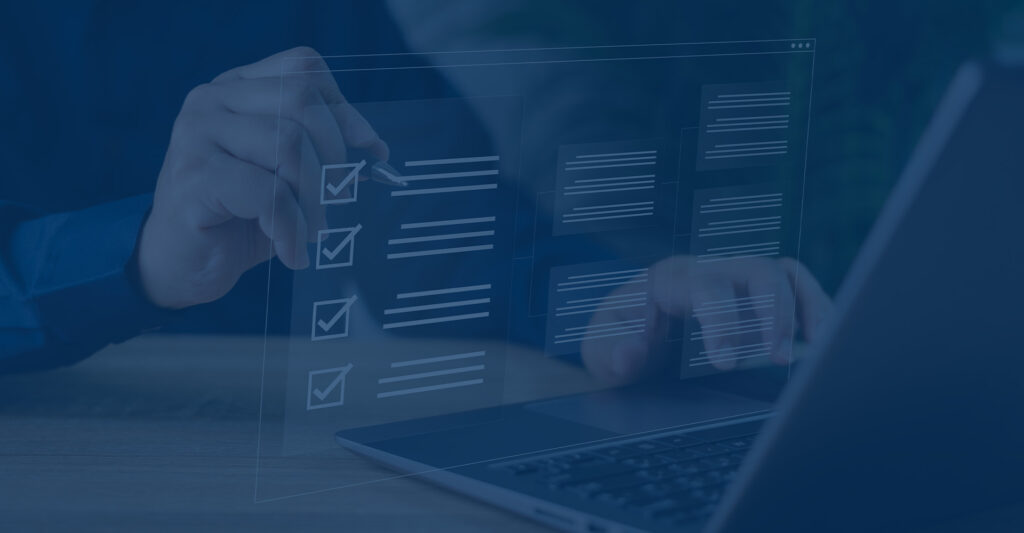 Man checking off list while working on computer