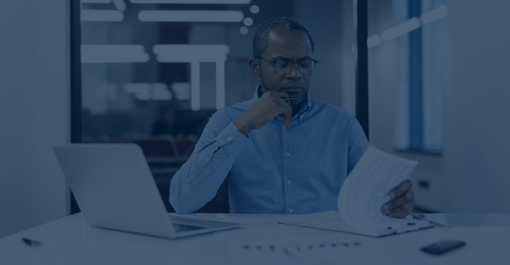 Plan Sponsor reviewing paperwork at desk